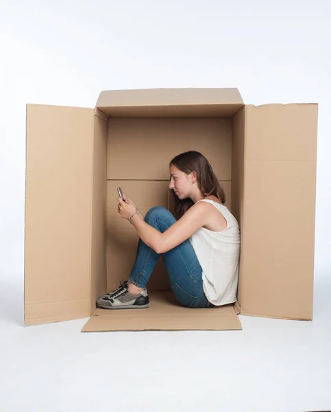 Jonge Vrouw Met Behulp Van Smartphone Een Doos Geïsoleerd Wit — Stockfoto