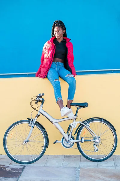 Boldog afro-amerikai nő kerékpárral ül a színes utcán — Stock Fotó