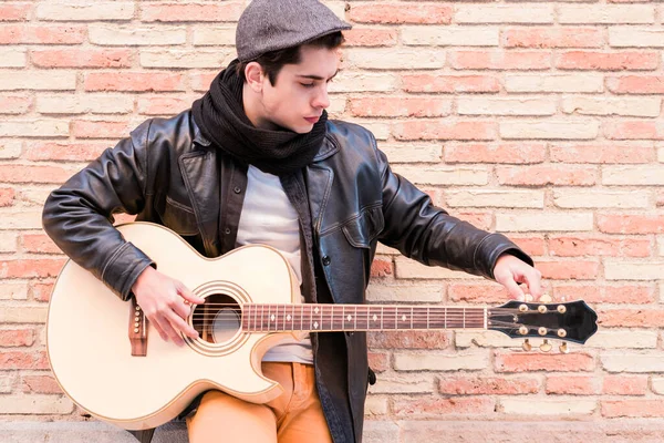 Um músico de rua a afinar a guitarra. Dedos girando os pinos de afinação de uma guitarra acústica — Fotografia de Stock