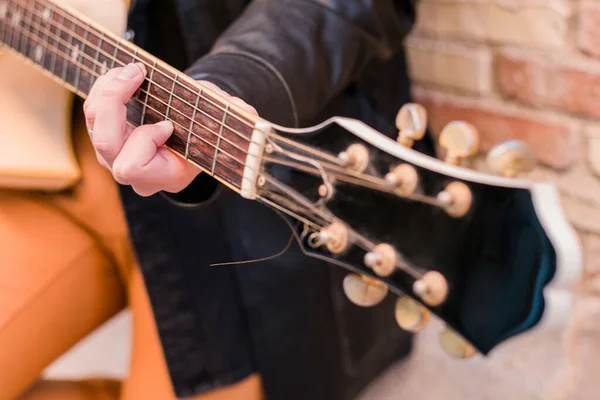 Músico callejero tocando la guitarra. Enfoque selectivo en la mano izquierda. Cuello de guitarra de cerca. —  Fotos de Stock