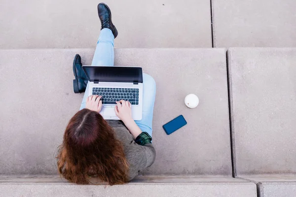 Портрет женщины-фрилансера с ноутбуком, сидящей на лестнице на городской улице. Концепция блогеров. — стоковое фото