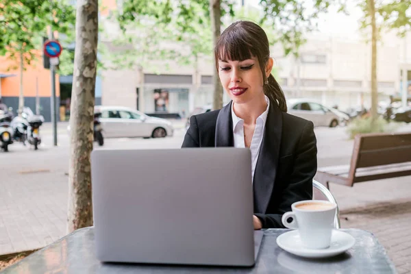 Портрет красивой деловой женщины с ноутбуком, сидящей в кафе на открытом воздухе — стоковое фото