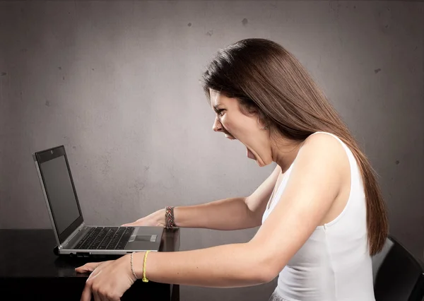 Donna d'affari arrabbiata che lavora con un computer portatile — Foto Stock