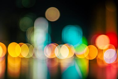 Gece gökdelenlerinin ışıkları nehre yansıyor. Resim bokeh etkisi ile bulanıklaştırıldı.