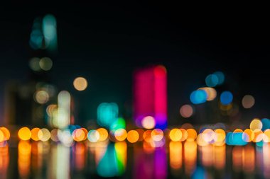 Gece gökdelenlerinin ışıkları nehre yansıyor. Resim bokeh etkisi ile bulanıklaştırıldı.