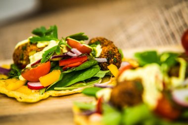 Taze sebze ve falafel ile doldurulmuş mısır tortilla. Restorandaki yemek. Yemek tasarımı ve restoran yemeği.