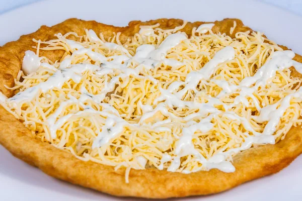 Langolar rendelenmiş peynir ve sosla doldurulmuş. Langolar geleneksel bir Macar yemeğidir. Yemek tasarımı ve restoran yemeği.