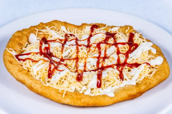 Langolar rendelenmiş peynir ve sosla doldurulmuş. Langolar geleneksel bir Macar yemeğidir. Yemek tasarımı ve restoran yemeği.