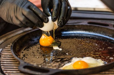 Şef ızgarada yumurta pişirir. Kapat.