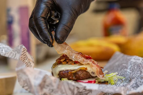 Şef taze lezzetli hamburgerleri malzemelerle hazırlar. - Yakın çekim. Fast food 