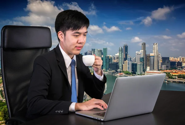 Portrait of goodlooking Asian man sitting at table at working of — Stock Photo, Image