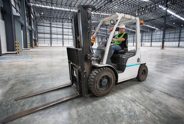 Adam forklift kullanıyor. 