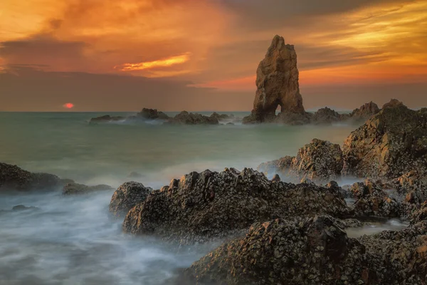 海浪在日落时撞到石头 — 图库照片