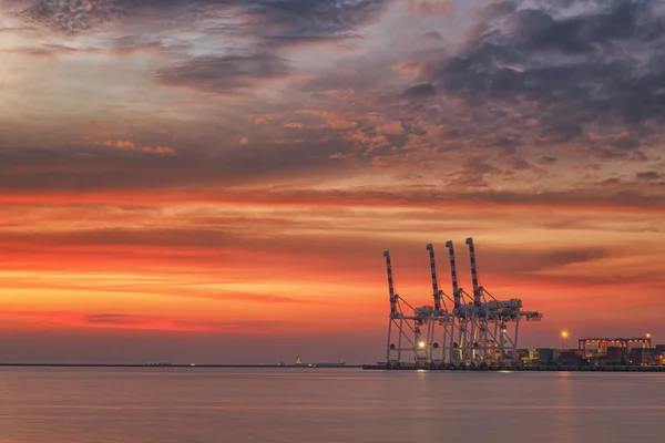 Cranes and industrial cargo ships in Varna port at sunset — Stock Photo, Image