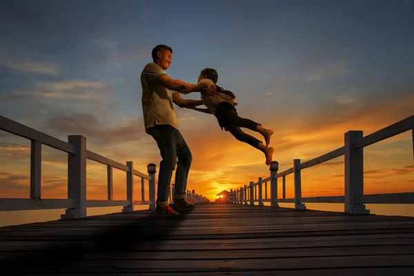 Padre juega con su chica en la playa al atardecer — Foto de Stock