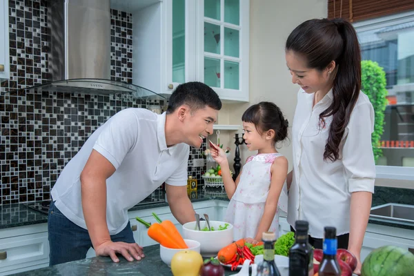 Happy family preparing vegetables together