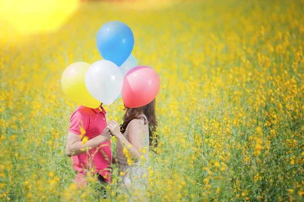 Couple kissing in the garden yellow flowers — Stock Photo, Image