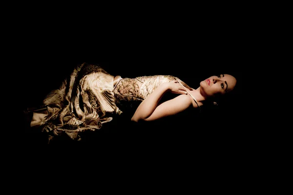 Μελαχρινή γυναίκα με φόρεμα βράδυ, ξαπλωμένος Εικόνα Αρχείου