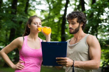 trainer showing training table to woman