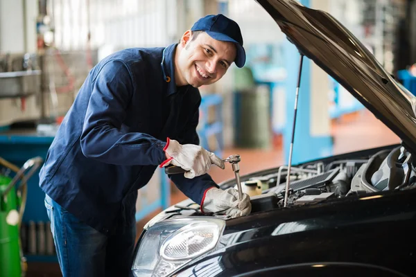 Mechanic holding wrench in garage — Stock Photo, Image