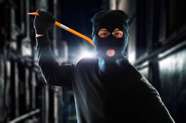 Criminal holding crowbar in night clipart