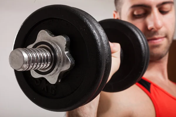 Bodybuilder using dumbbell — Stock Photo, Image