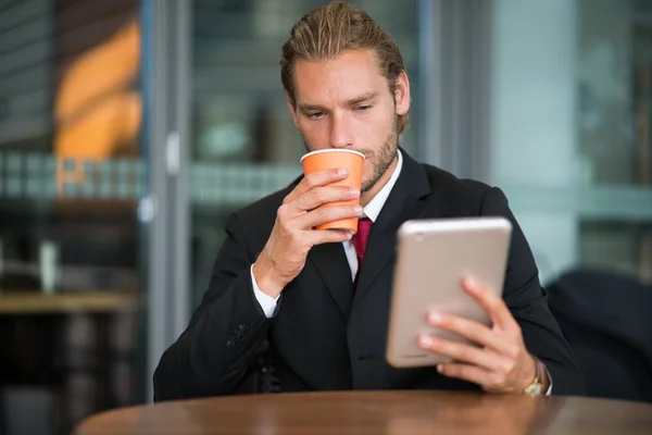 Empresário usando seu tablet no café — Fotografia de Stock