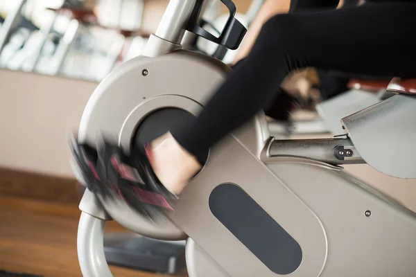 Vrouw uit te werken op de hometrainer — Stockfoto