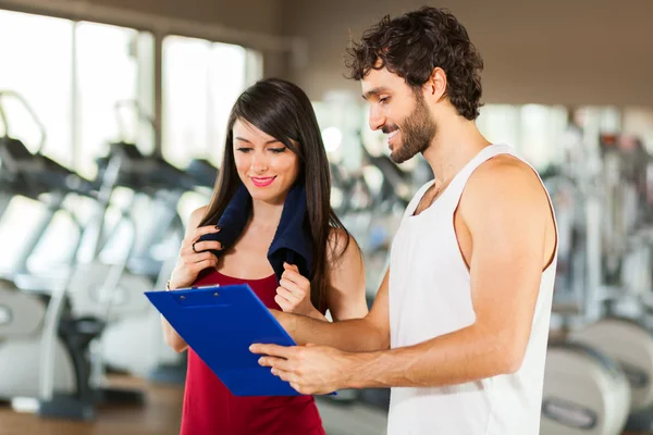 Femme parlant à un entraîneur de fitness — Photo