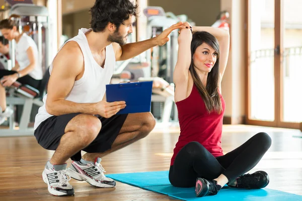 Trainer een oefening uit te leggen aan de vrouw — Stockfoto