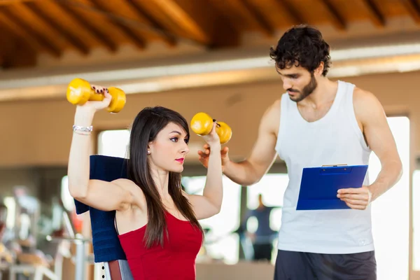 Trainer een oefening uit te leggen aan de vrouw — Stockfoto