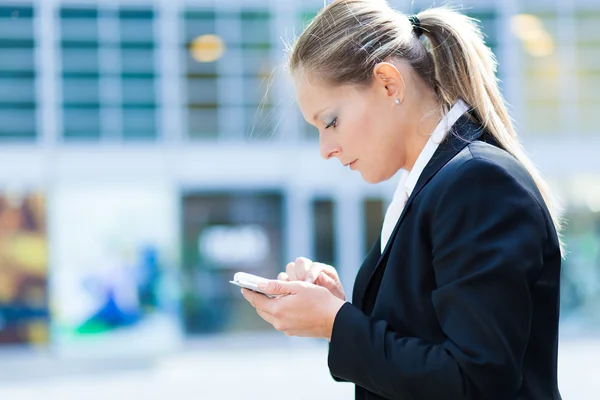 Vrouw met behulp van mobiele telefoon buitenshuis — Stockfoto