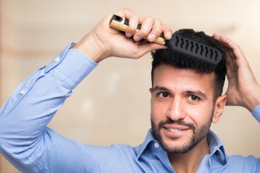 Adam saçını tarıyor.