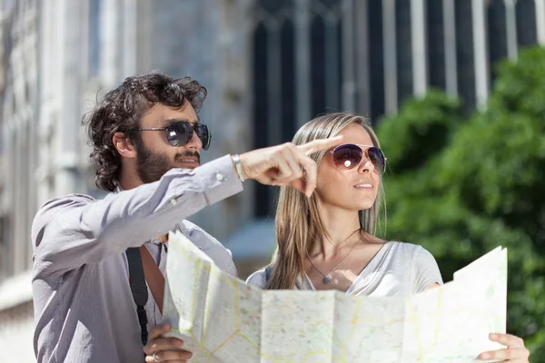 Tourists couple holding map — Stock Photo, Image