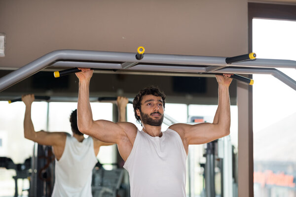 Man doing pull-ups in gym