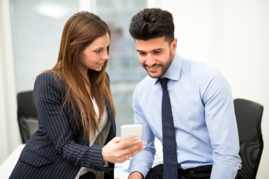iş kadını gösteren Smartphone-e doğru iş arkadaşı