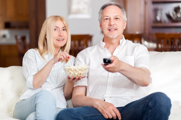 Äldre par i soffan tittar på tv — Stockfoto