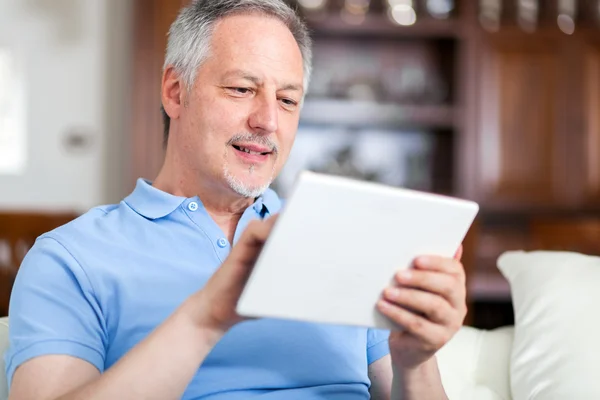 Uomo maturo utilizzando tablet in camera — Foto Stock