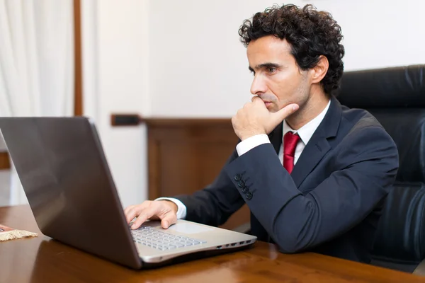 Biznesmen korzystający z laptopa w biurze — Zdjęcie stockowe