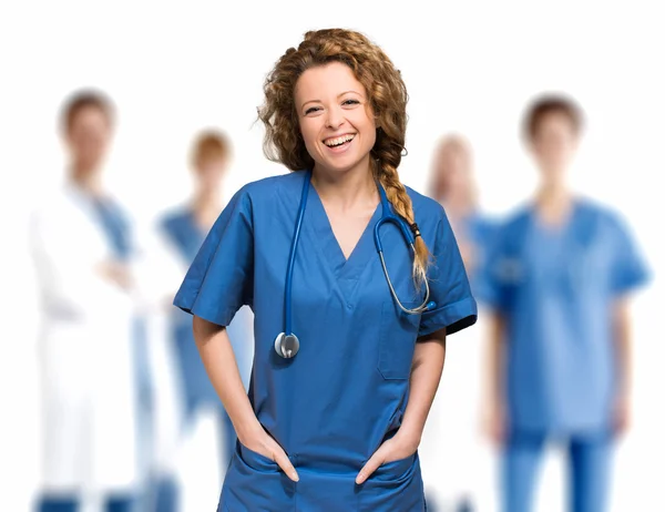 Tıbbi ekip önünde gülümseyen hemşire — Stok fotoğraf