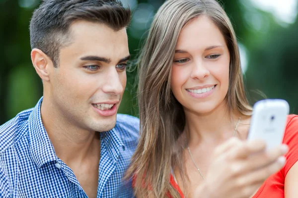Usmívající se pár pomocí telefonu — Stock fotografie