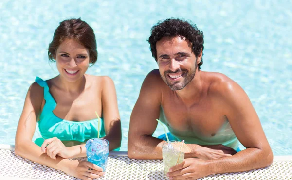 Paar trinkt Cocktails im Pool — Stockfoto