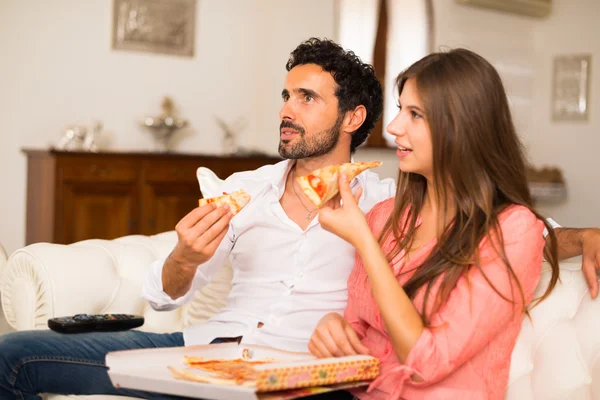 Casal assistindo tv enquanto come pizza — Fotografia de Stock