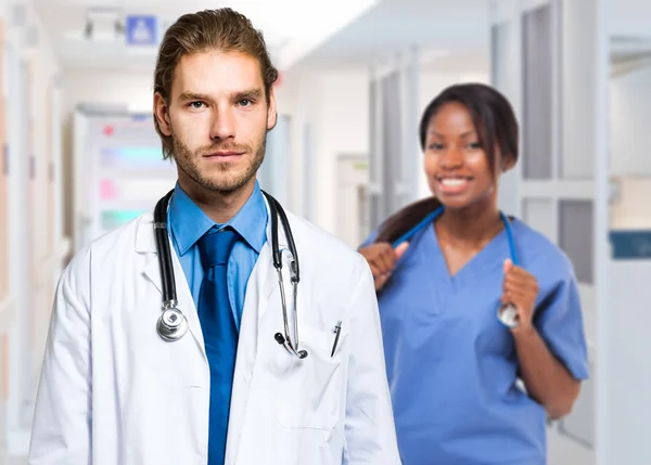 Medico di sesso maschile con stetoscopio davanti al collega — Foto Stock