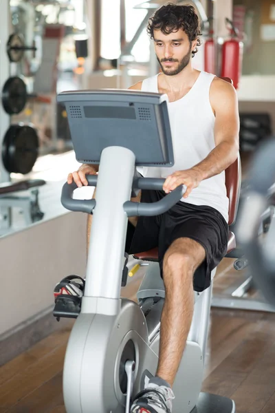 Man working out on stationary bike — Stock Photo, Image