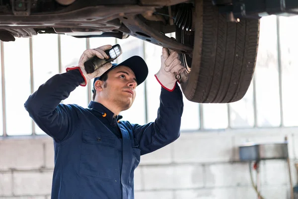 Mechanic inspecting car — Stock Photo, Image