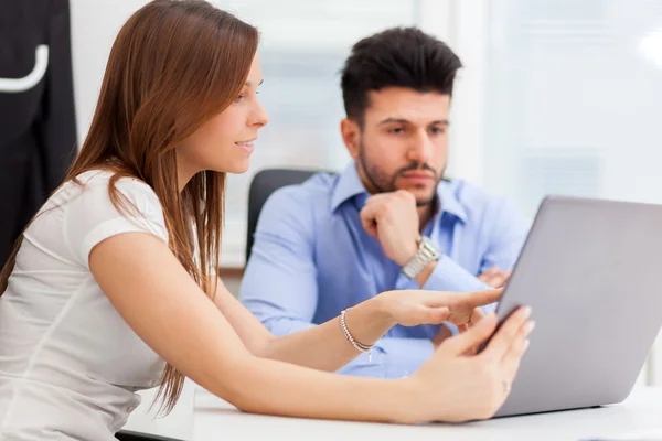 Geschäftsfrau zeigt ihrem Kollegen etwas in Laptop — Stockfoto