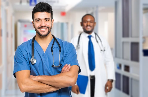 Medico con le braccia incrociate di fronte al collega — Foto Stock