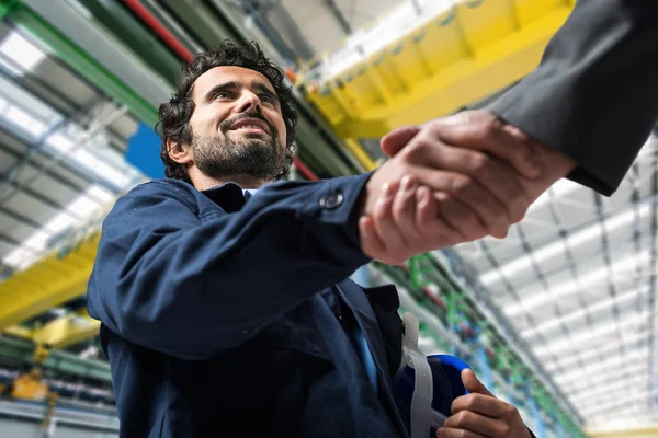 Männer beim Händeschütteln in einer Industrieanlage — Stockfoto