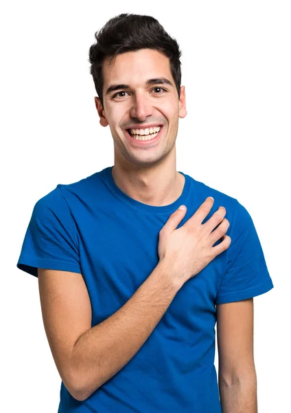 Göğüs üzerinde el ile gülümseyen genç adam — Stok fotoğraf